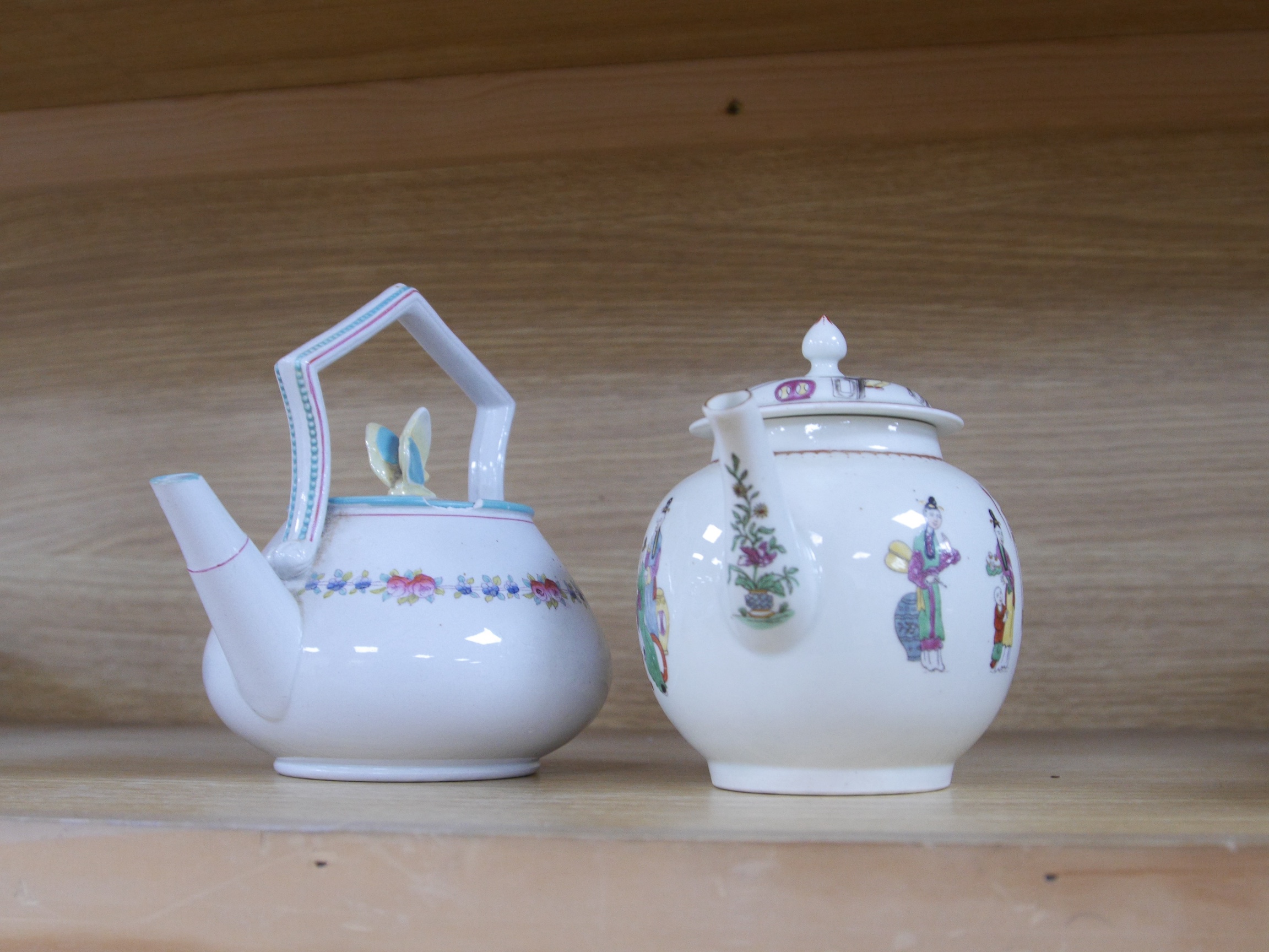 A Worcester chinoiserie teapot, c.1770 and a Victorian teapot with decorative butterfly cover, chinoiserie teapot 16cm high. Condition - damage to rim of Victorian teapot.